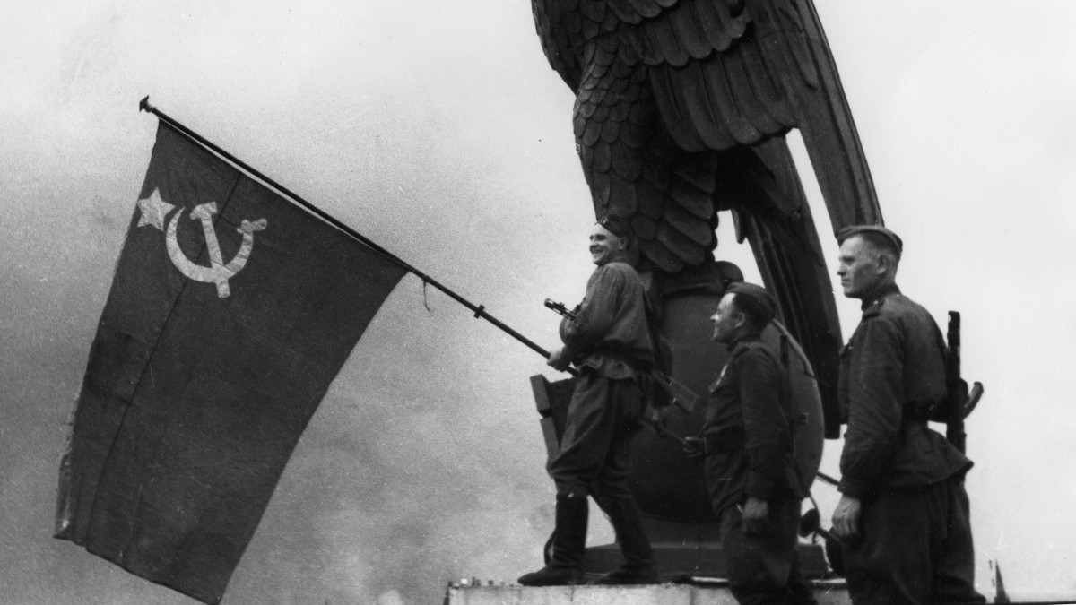 Красноармейцы с флагом СССР у имперского орла над главным входом аэропорта Темпельхоф