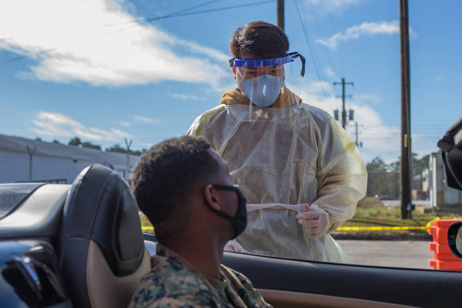Сотрудник военно-морского медицинского центра Кэмп-Лежен, Северная Каролина, готовится провести обследование на COVID-19 у капрала морской пехоты
