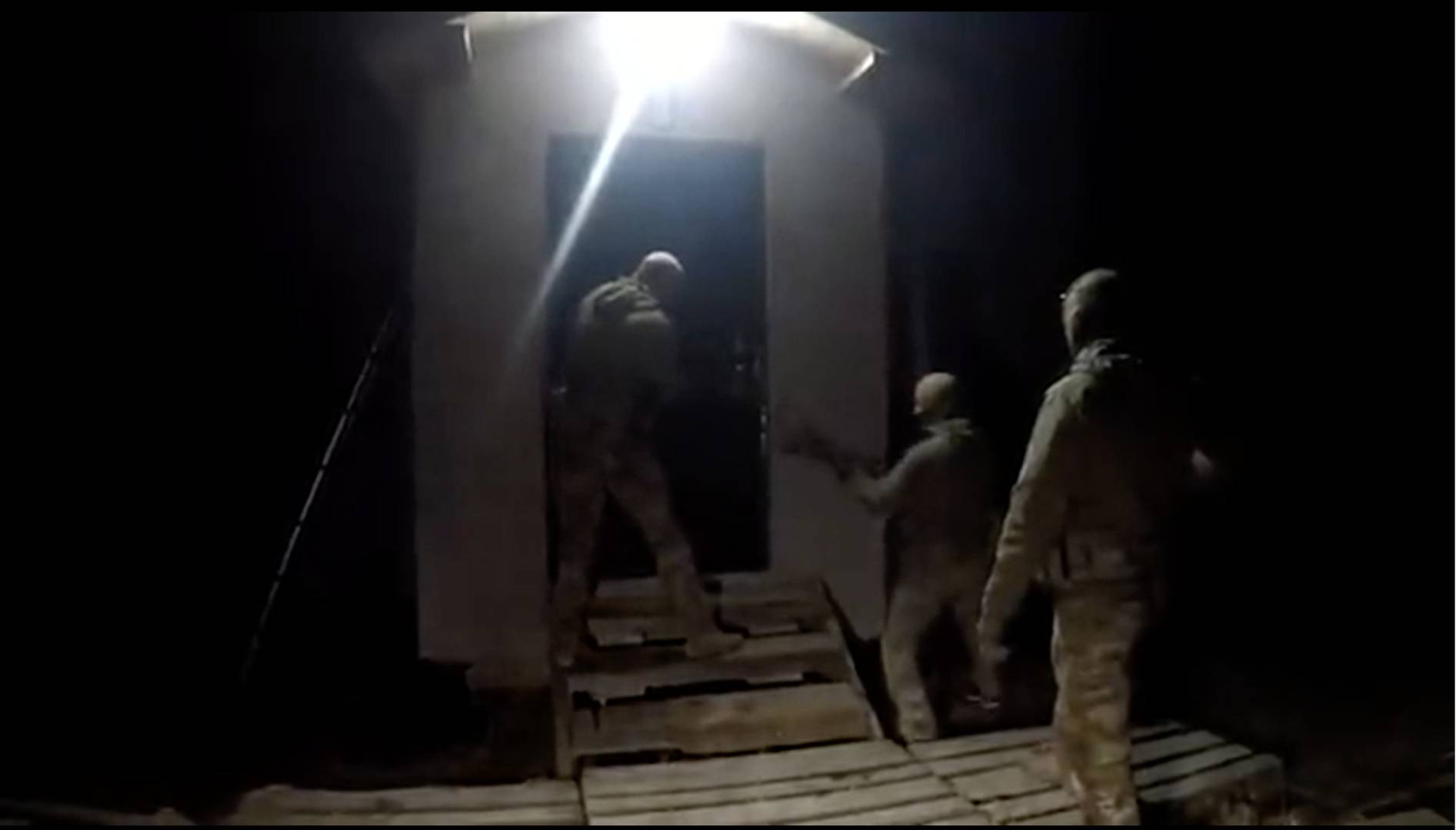 Оперативники ФСБ ломают дверь дома, где укрылся террорист