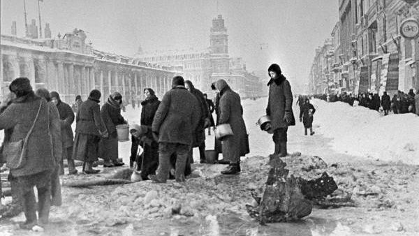 Жители блокадного Ленинграда набирают воду, появившуюся после артобстрела в пробоинах в асфальте на Невском проспекте, фото Б. П. Кудоярова, декабрь 1941