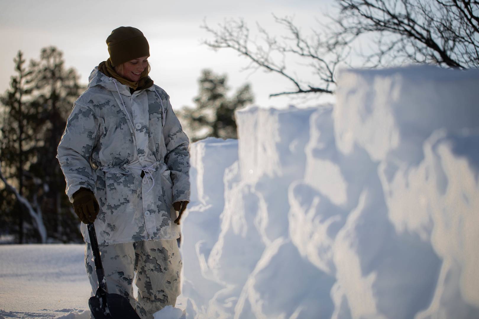Морской пехотинец США строит снежную стену во время тренировок в холодную погоду недалеко от Бьерквика, Норвегия