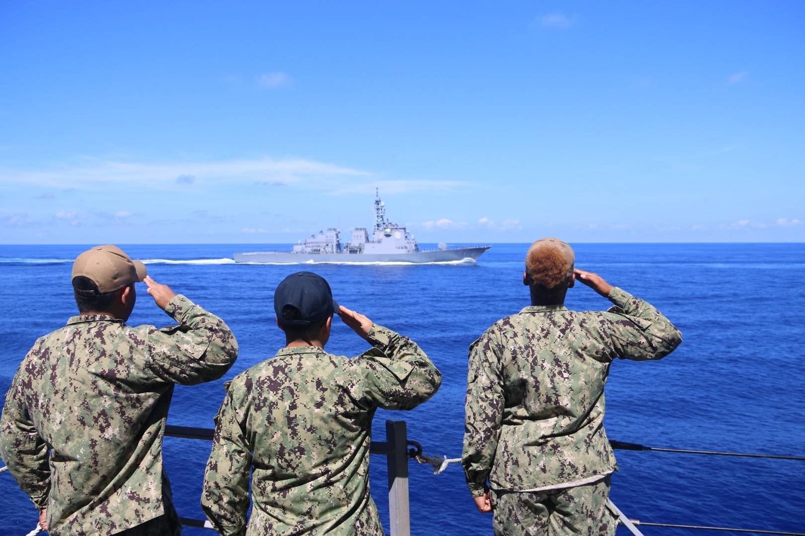 Американские моряки на борту эсминца УРО класса Arleigh Burke приветствуют военный корабль союзников