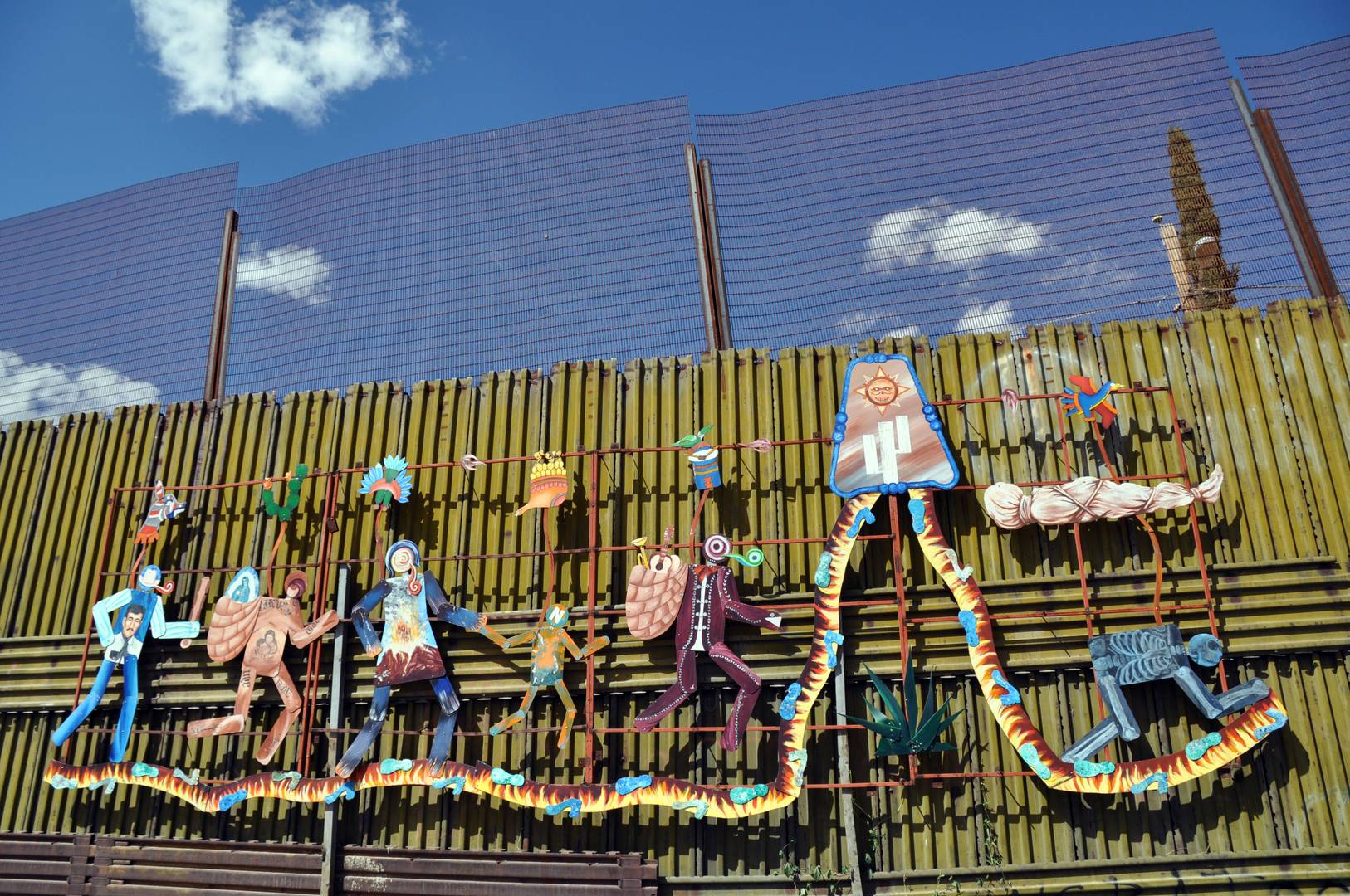 Пограничная стена США с Мексикой. Фреска под названием «Пасео Гудидад» (Парад человечества). На ней изображены трудности, с которыми сталкиваются мигранты по пути в США 
