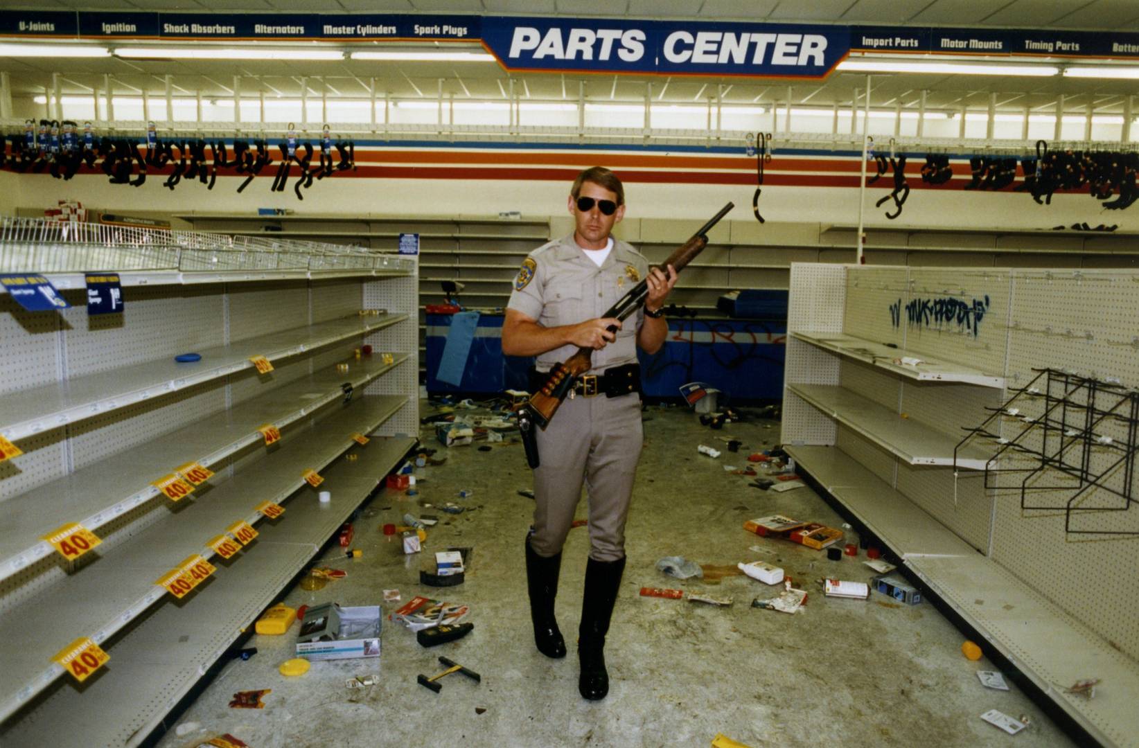 Вооруженный полицейский в разграбленном магазине во время черного бунта в Лос-Анджелесе, США, 1992 год.
