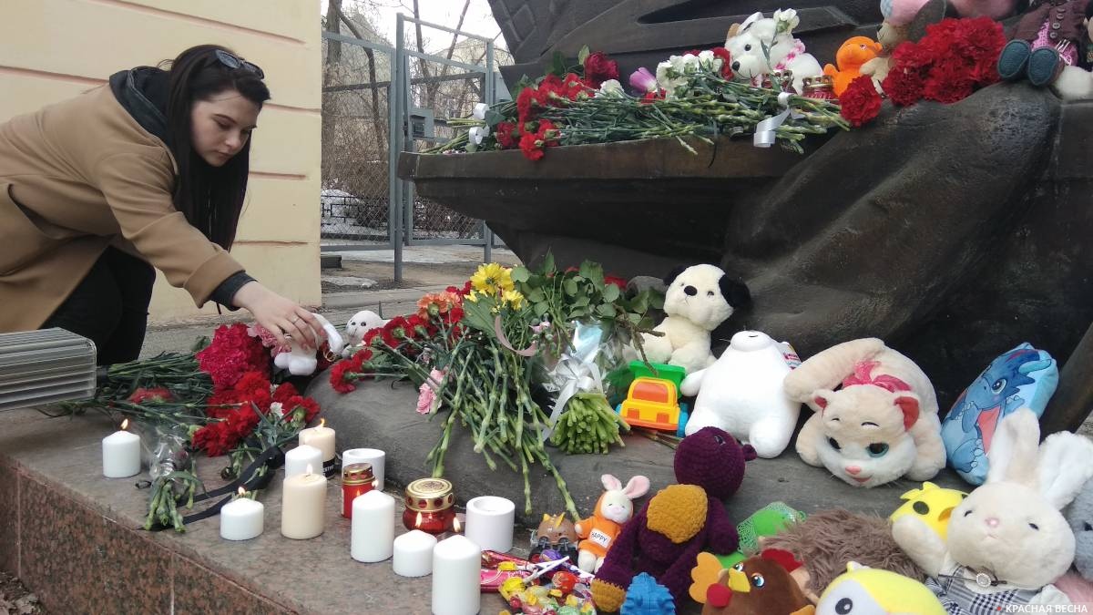 Девушка кладет игрушку к спонтанному мемориалу в честь погибших в «Крокус Сити», Воронеж, 23 марта 2024 года