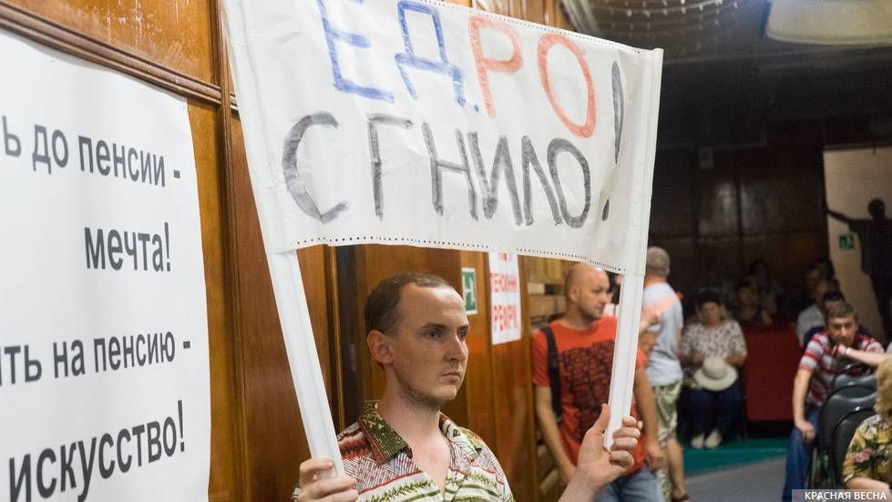 Активист держит плакат «ЕДРО Сгнило!» на собрании КПРФ против пенсионной реформы