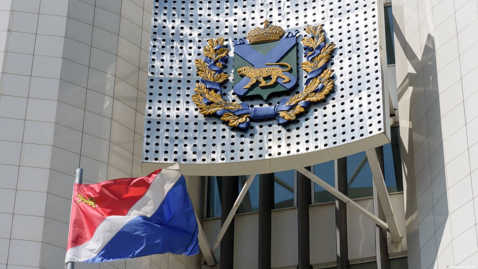 Герб и флаг Приморского края на здании краевой администрации, Владивосток, Россия.