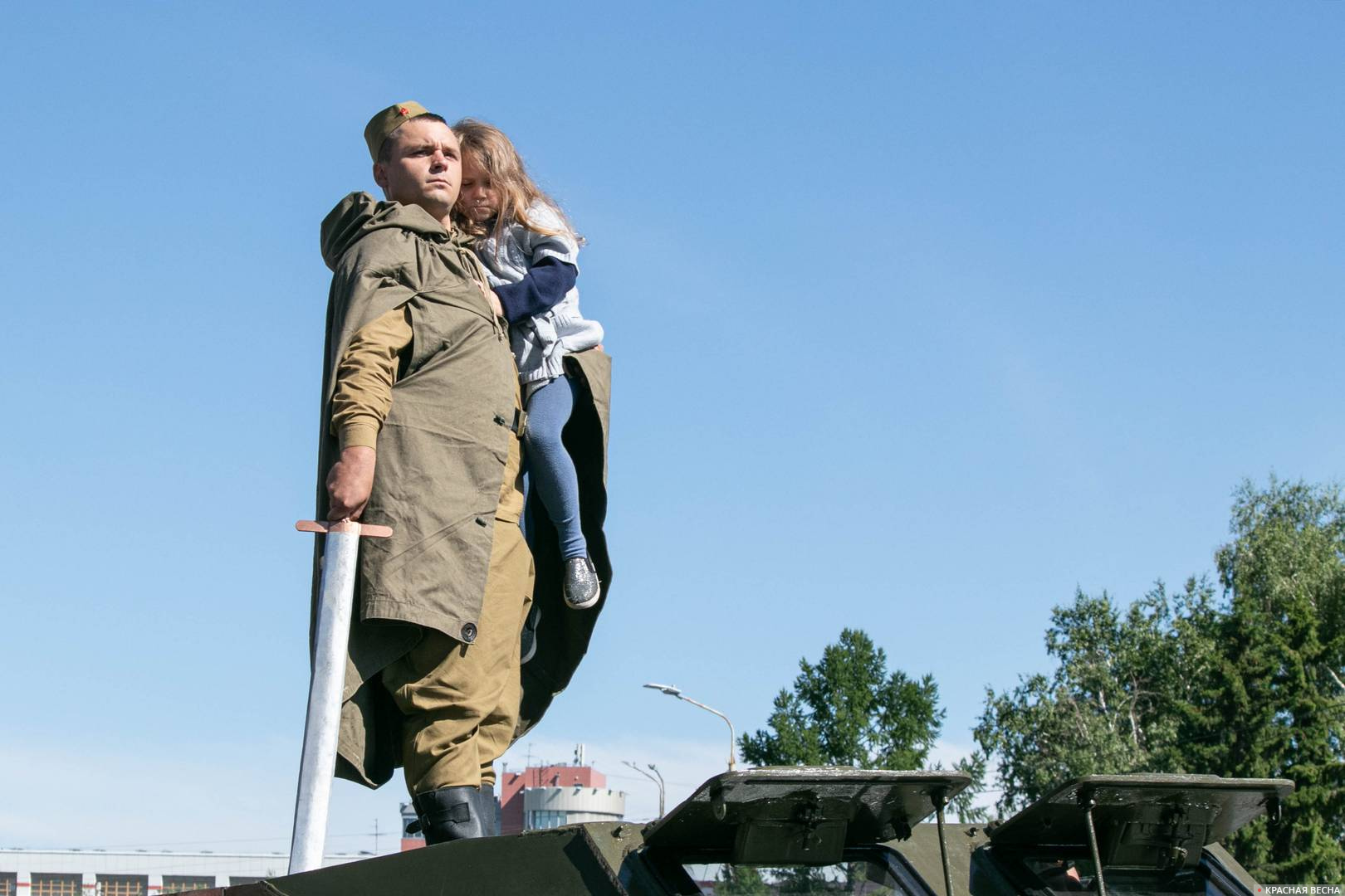 Солдат с девочкой на руках на крыше советского легкого бронетранспортера БТР-40