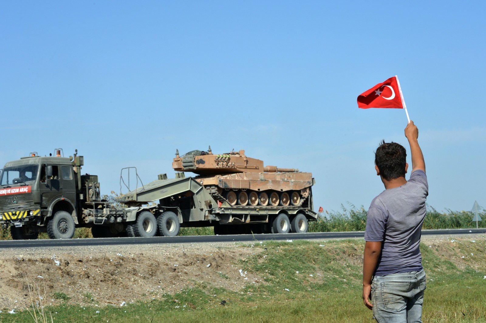 Человек приветствует колонну турецкой военной техники