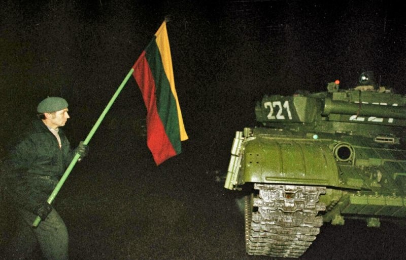 Один из протестующих с литовским триколором в руках около советского танка. Вильнюс. Ночь 13 января 1991 года