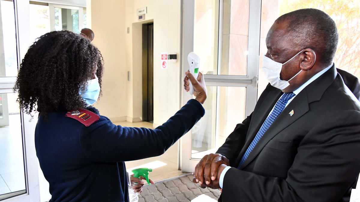 Президент ЮАР Сирил Рамофоса проходит проверку температуры во время инспекции учебных заведений
