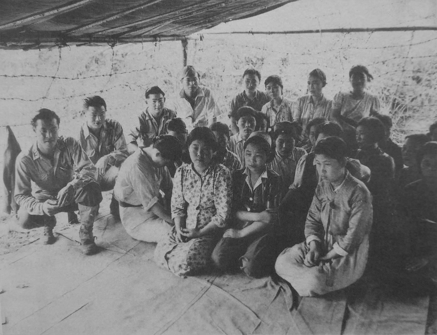 Кореянки, освобожденные американскими войсками из японского военного борделя в Бирме. Рядом с ними находятся американские военнослужащие японского происхождения, которые проводили опрос после освобождения. 1944. Бирма