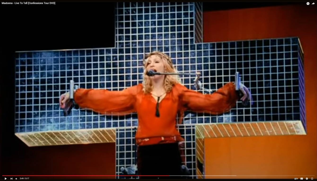 Певица Мадонна, распятая на кресте во время исполнения песни «Live To Tell» во время мирового тура «Confessions Tour»