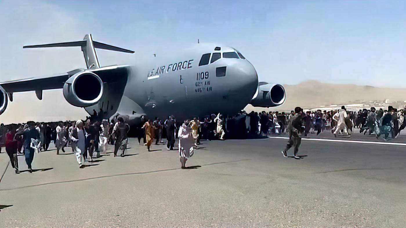 Жители Кабула пытаются зацепиться за взлетающий американский военный транспортный самолет