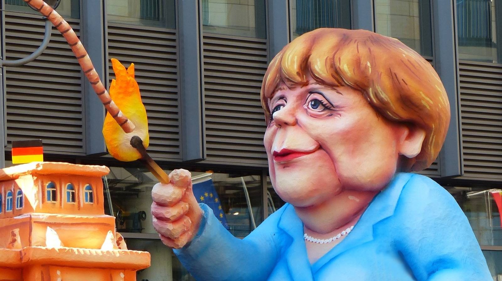 Меркель поджигает фитиль. Карикатура.