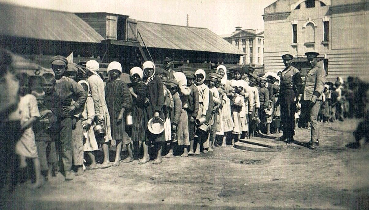 Дети в очереди за едой. Рядом с детьми офицеры в английской форме. Омск. Июль 1919