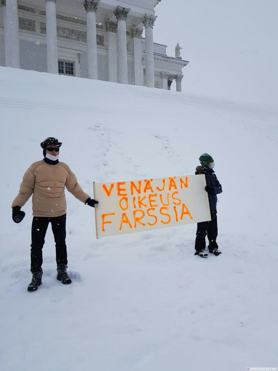 Двое с плакатом на финском языке «Правосудие в России — фарс» на Сенатской площади Хельсинки.